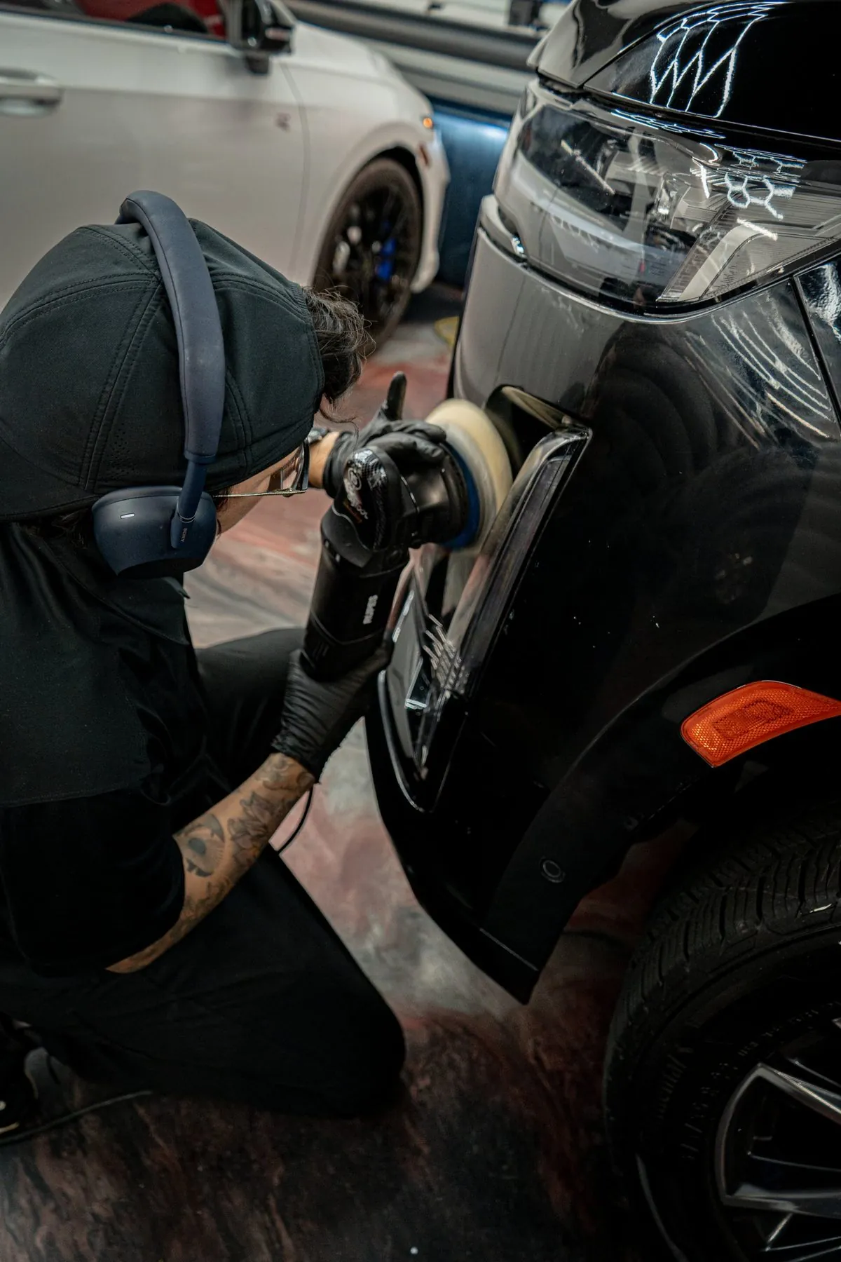 Machine polishing a black SUV before ceramic coating